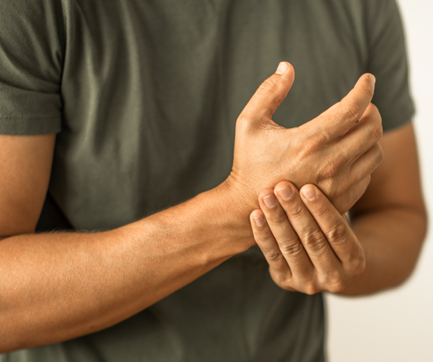Person experiencing wrist pain while holding their wrist with one hand, indicating discomfort or injury.