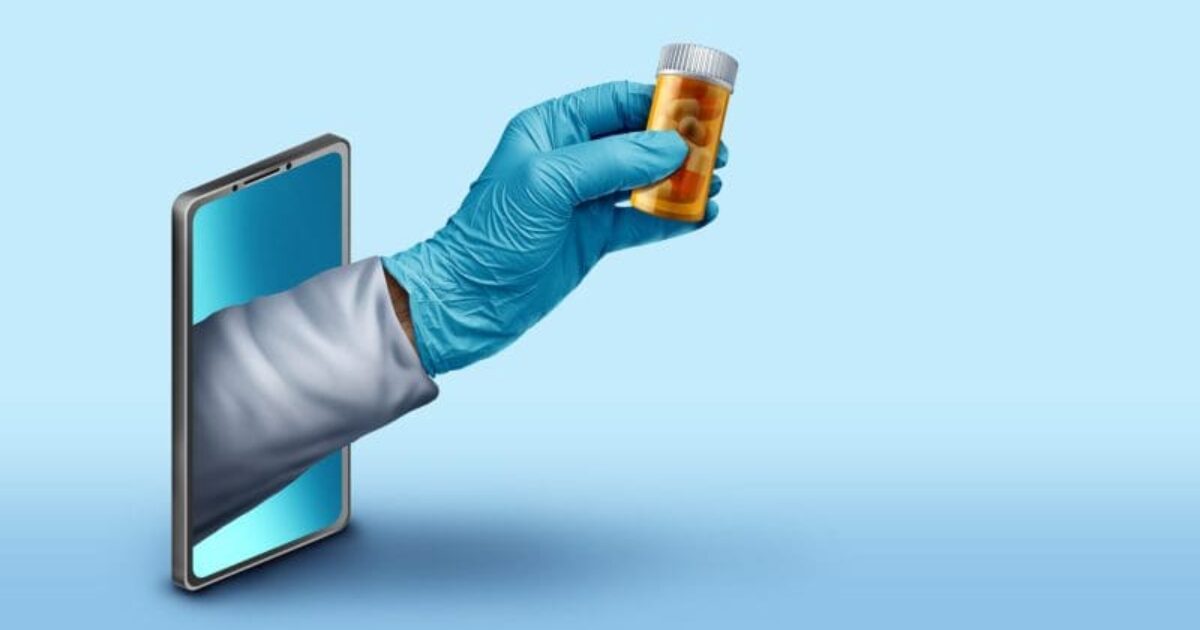 Hand in a blue glove holding a prescription bottle emerging from a smartphone, symbolizing telehealth and online pharmacy services.