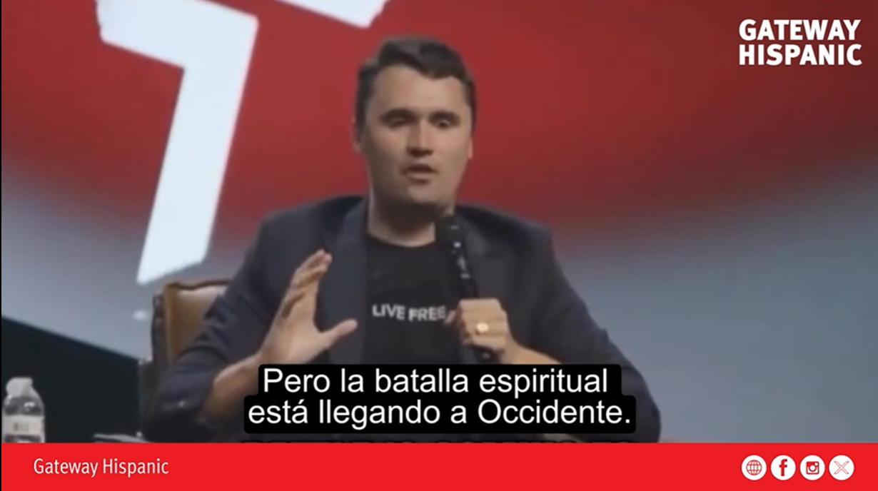 Speaker discussing spiritual battles in a conference setting, emphasizing the importance of awareness in the Western world.