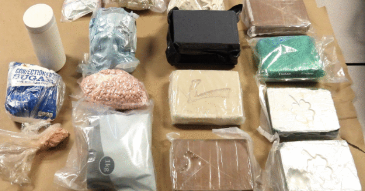 Assorted packages of substances including sugar and various colored materials, arranged on a brown surface for analysis or display.
