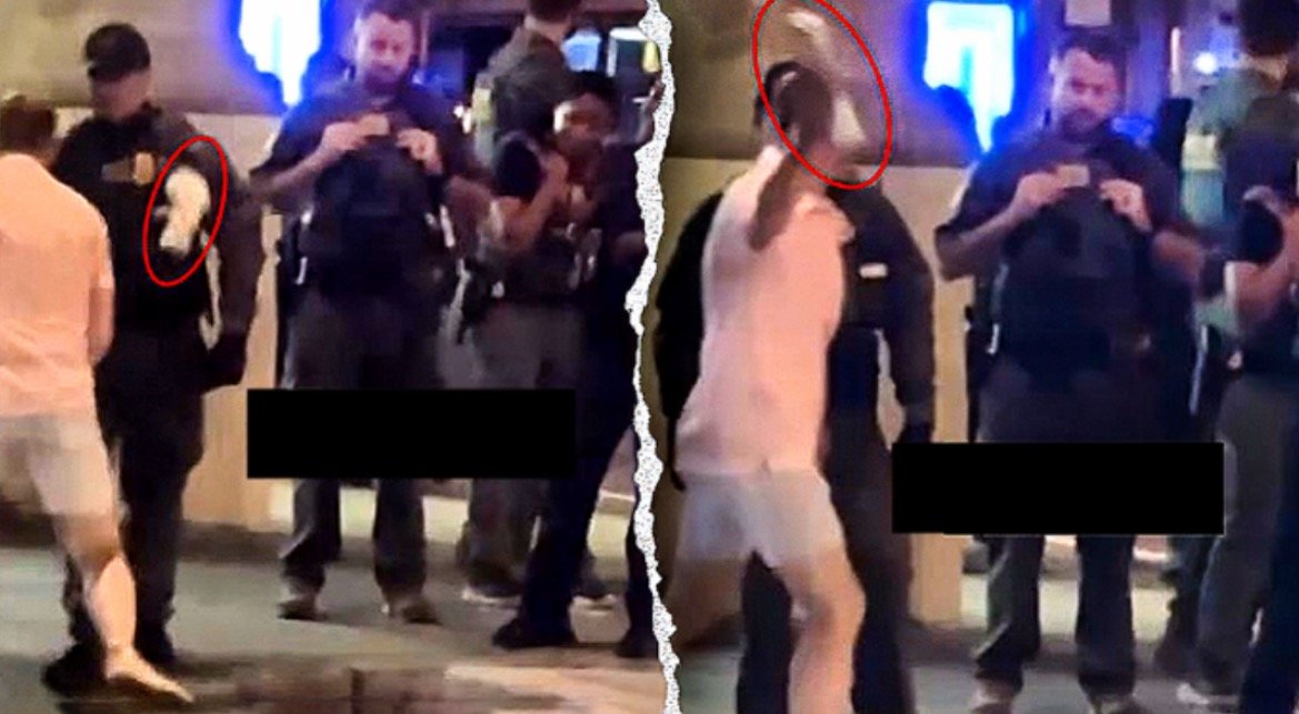 Police officers interact with a person in casual clothing during a nighttime street scene, capturing the moment on their phones.