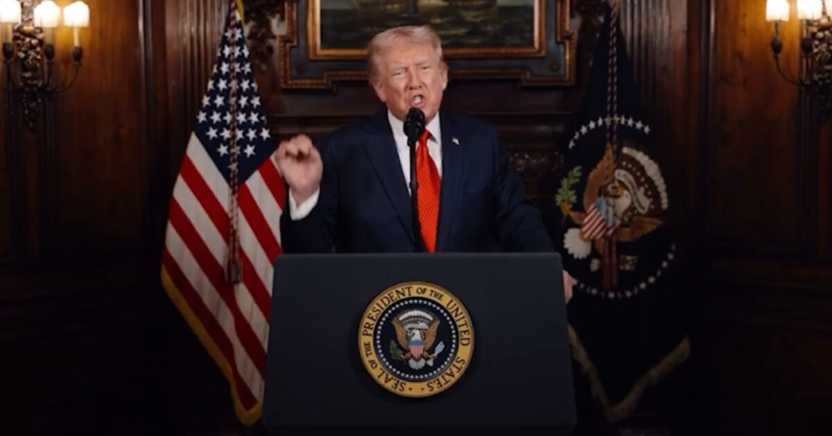 Donald Trump delivering a speech at a podium adorned with the presidential seal, flanked by American flags in an elegant room.