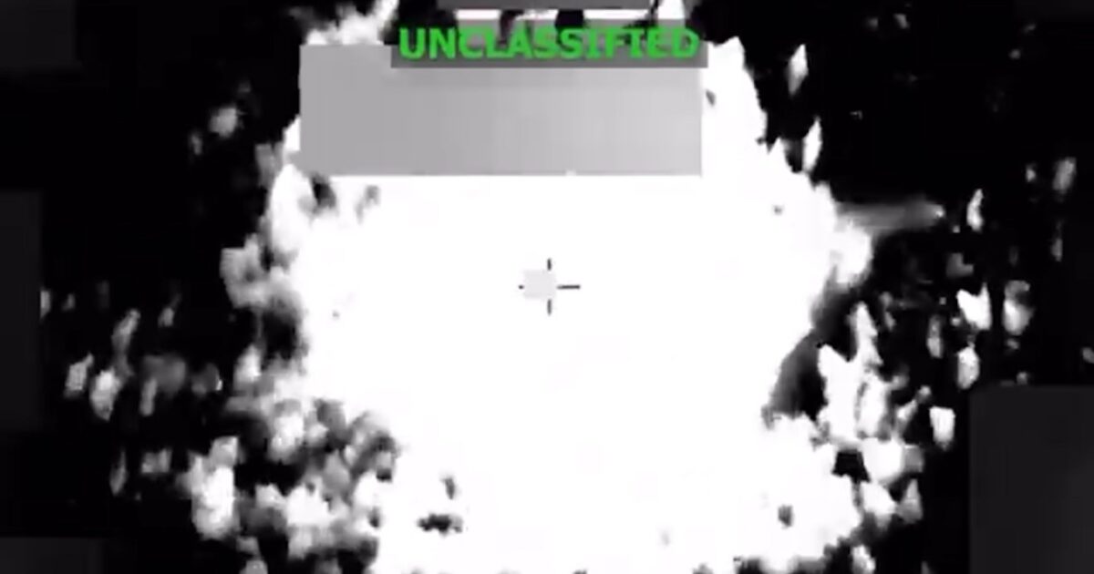 A thermal imaging view of an explosion, labeled as unclassified, showcasing smoke and debris in a high-contrast monochrome setting.