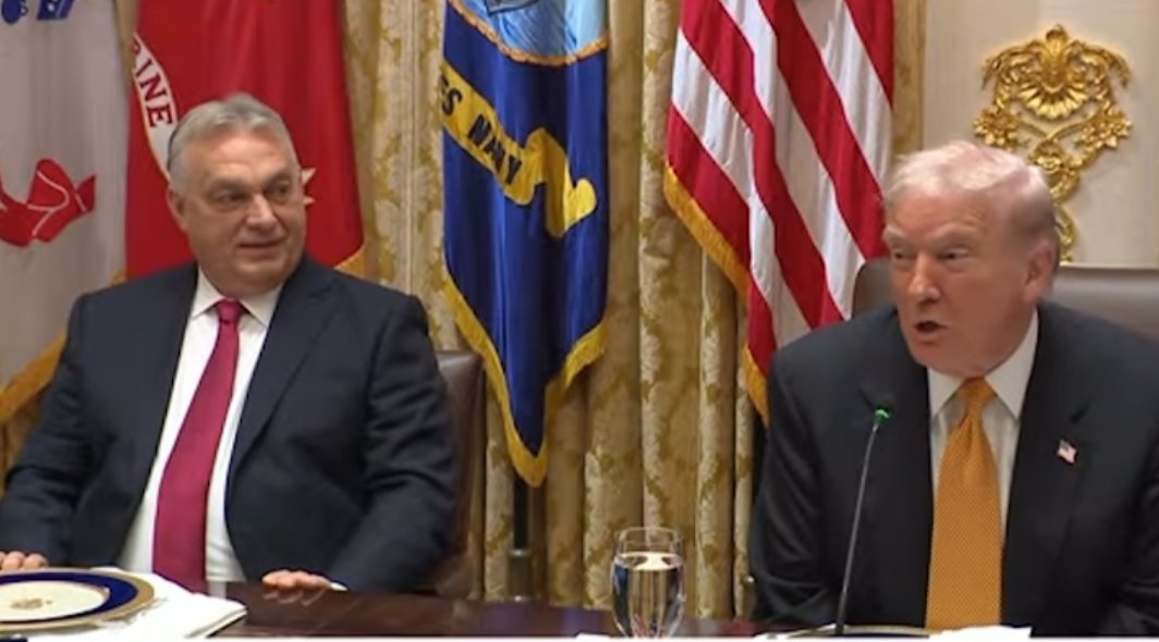 Former President Donald Trump speaks during a meeting with Hungarian Prime Minister Viktor Orbán, with American flags and military insignia in the background.