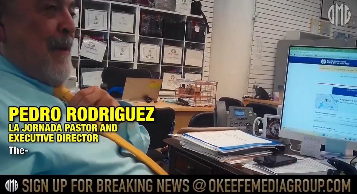Pedro Rodriguez, La Jornada pastor and executive director, sitting at his desk with a computer and paperwork in a busy office environment.