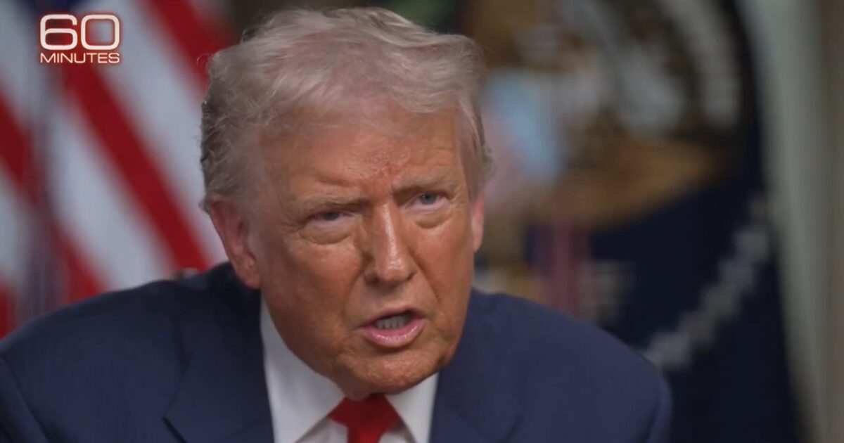 Close-up of a man speaking passionately during a televised interview, with American flags in the background, highlighting a significant moment in political discourse.