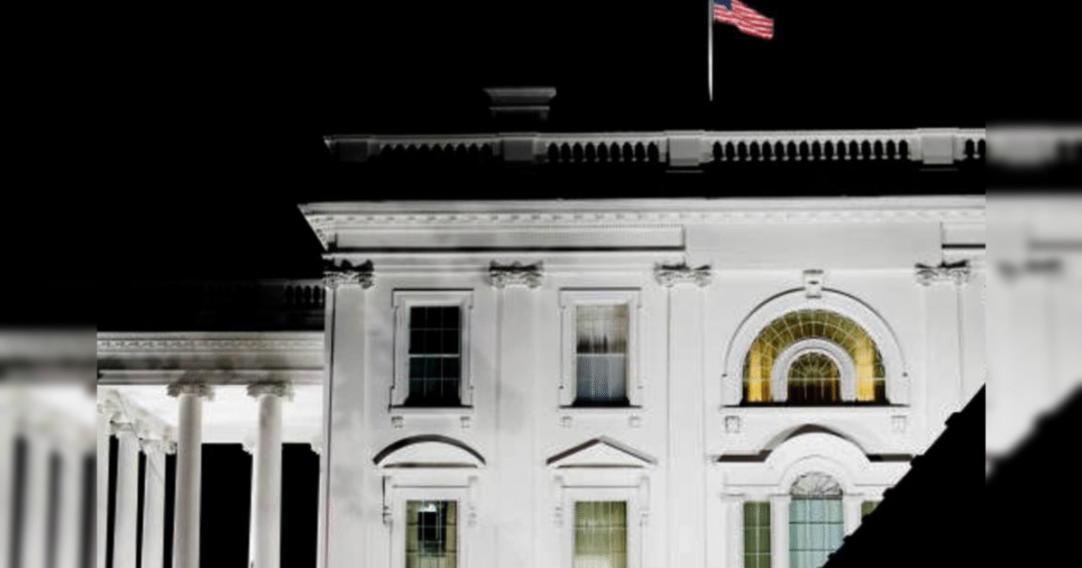 Illuminated White House at night with the American flag flying, showcasing its iconic architecture and historical significance.