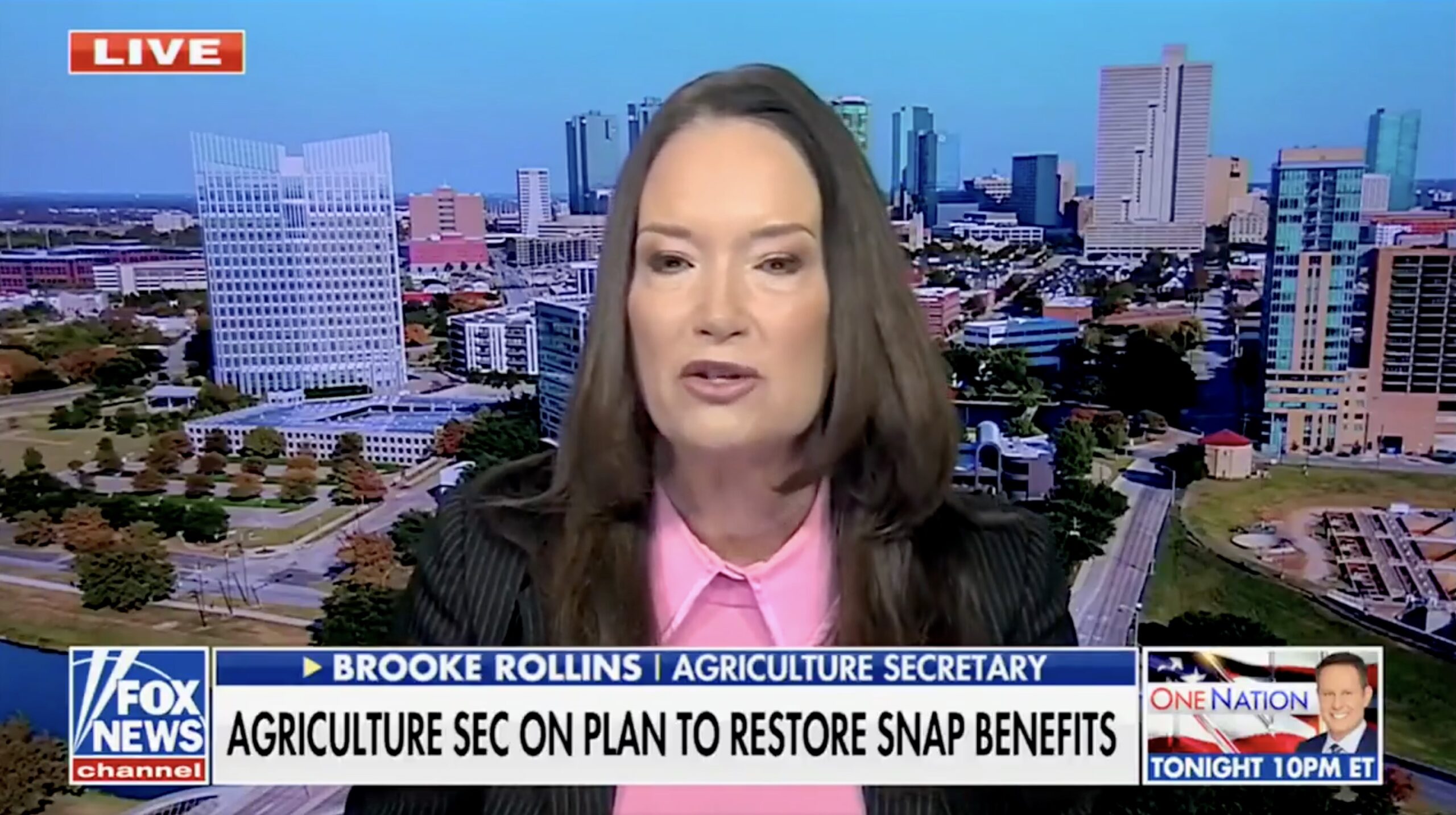 Agriculture Secretary Brooke Rollins discusses plans to restore SNAP benefits against a backdrop of a city skyline during a live Fox News broadcast.