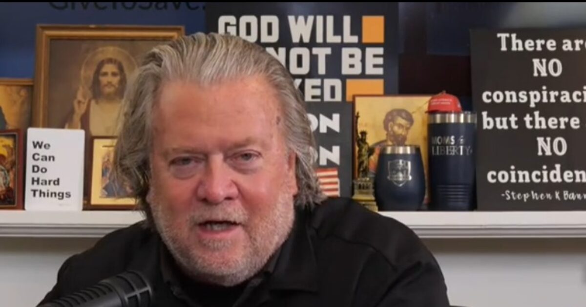 Steve Bannon speaking in front of a shelf decorated with religious icons and signs conveying motivational and controversial messages.