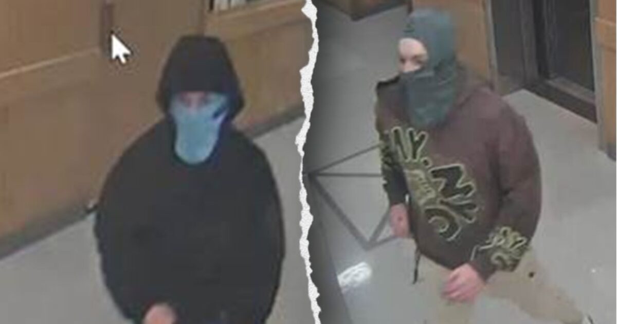 Two individuals wearing masks and hoodies captured on surveillance footage in a hallway, possibly involved in suspicious activity.