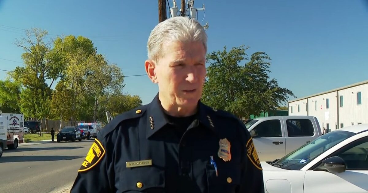 San Antonio police chief addressing the media at a scene with emergency vehicles in the background, highlighting public safety efforts.