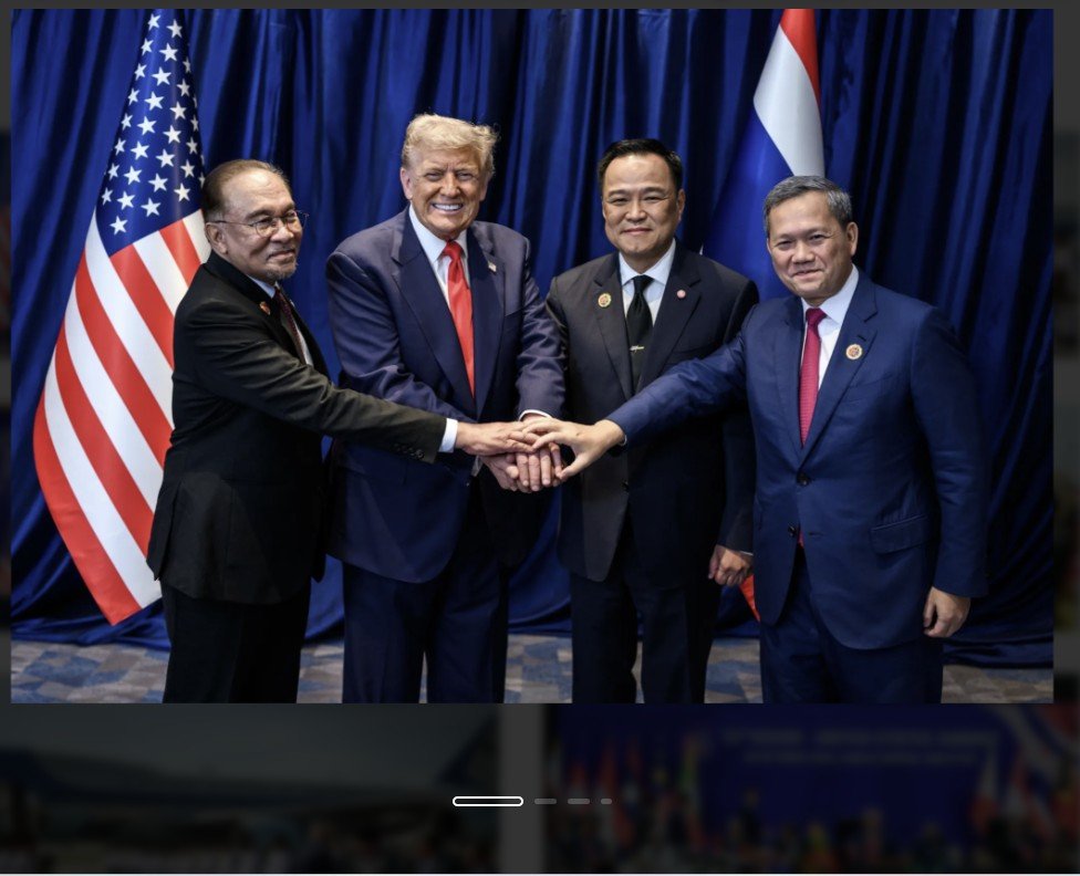 Leaders from different nations pose together, united in a handshake, with the American flag displayed prominently in the background.
