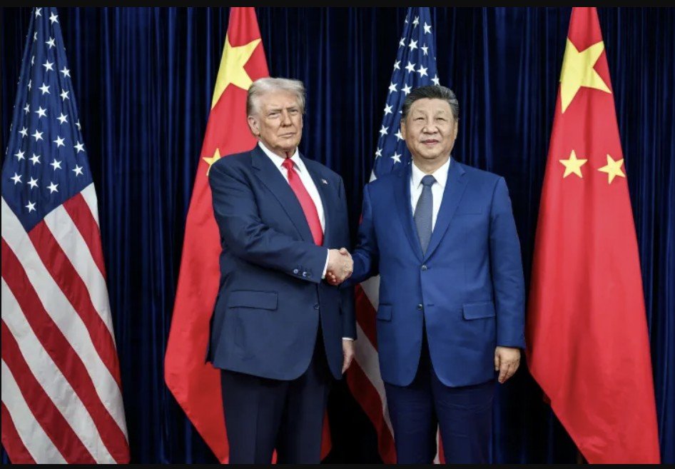 Donald Trump and Xi Jinping shake hands during a diplomatic meeting, with American and Chinese flags in the background, symbolizing U.S.-China relations.
